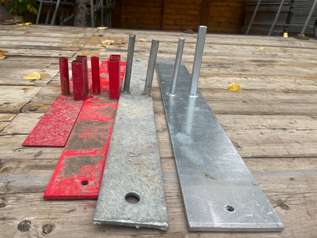 A typical red footing plate beside the longer, thicker StructSure galvanized footing