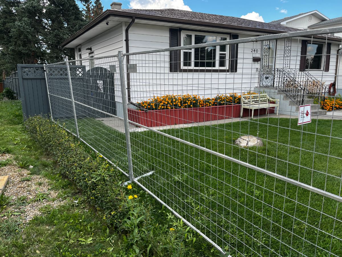 Galvanized temporary fence panels around a residential front yard