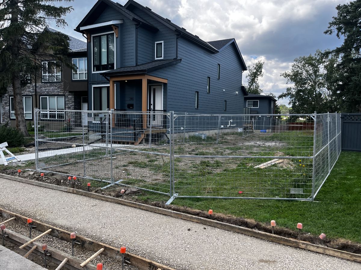 Galvanized temporary fence panels enclosing a new build lot on a corner