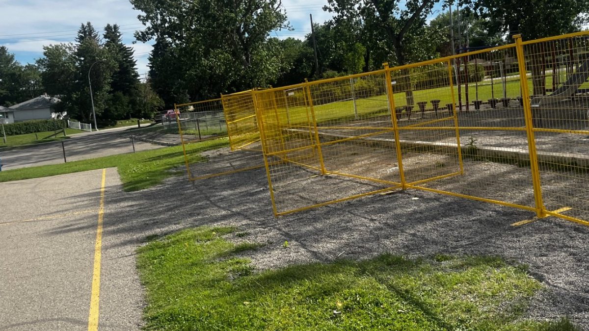 Yellow temporary fence panels closing off a school courtyard work area
