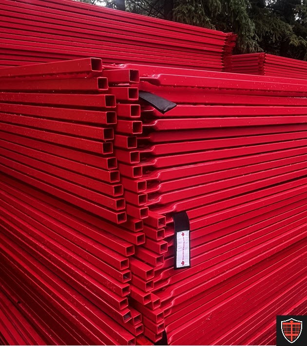 Close view of stacked red temporary fence panels showing the square tube frames and reinforced corners