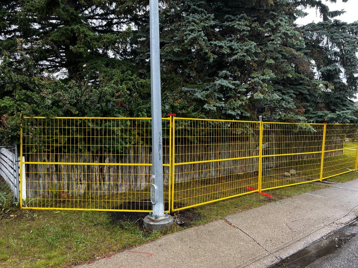 Red temporary fence around an excavation at a Calgary school