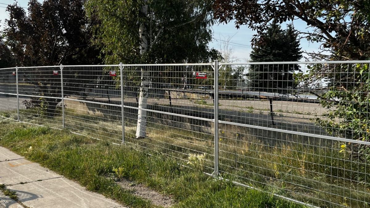 Galvanized temporary fence panels securing a commercial industrial site in Calgary
