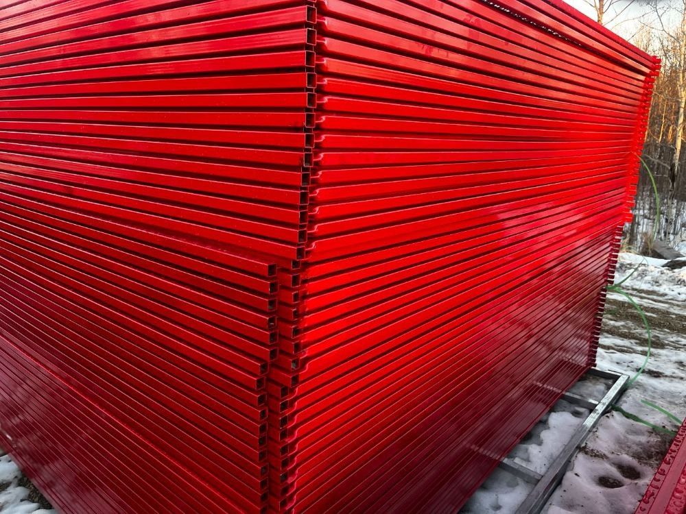 Stacked red temporary fence panels showing consistent panel height and length