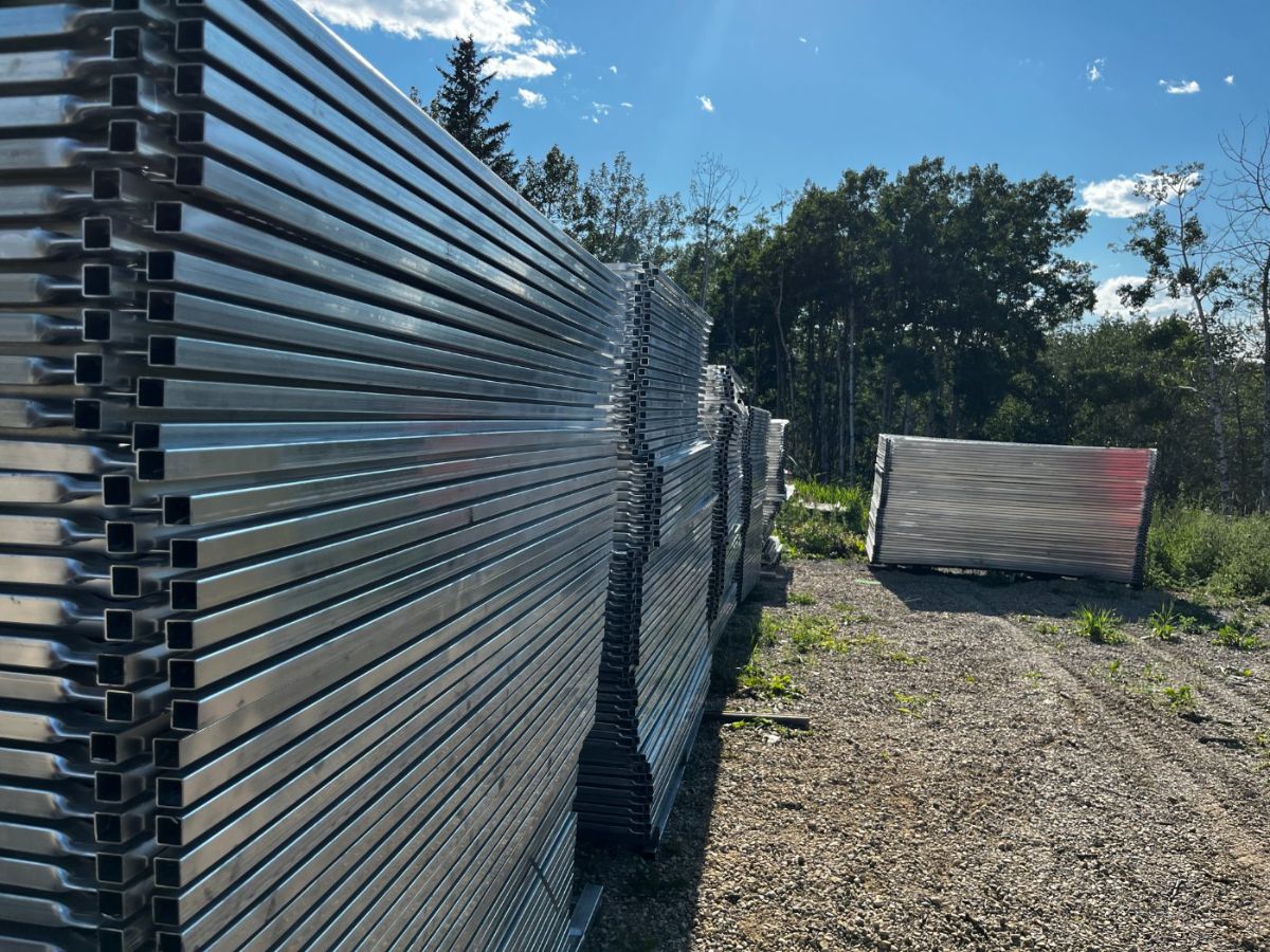 Long rows of galvanized temporary fence panels stacked in the StructSure yard