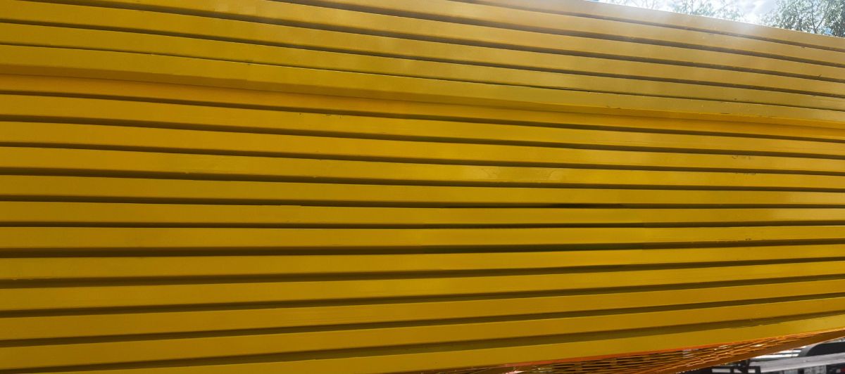 Stacked yellow powder coated temporary fence panels in the StructSure yard